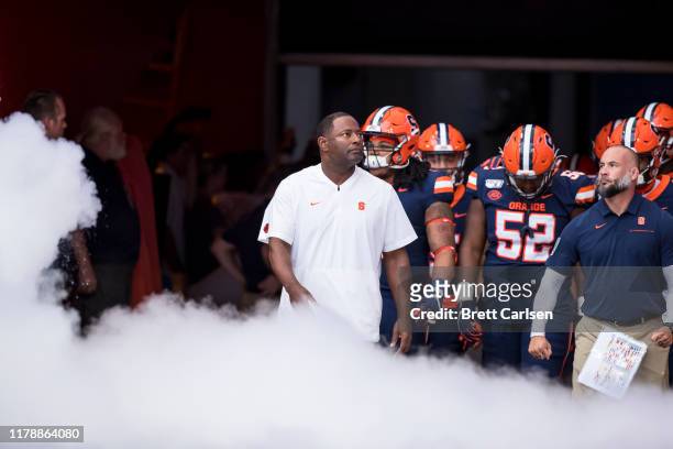 Syracuse Orange players and head coach Dino Babers stand amidst special effects before the game against the Holy Cross Crusaders at the Carrier Dome...