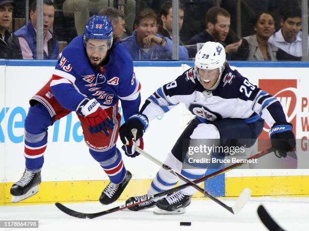 Mika Zibanejad of the New York Rangers skates against Patrik Laine of the Winnipeg Jets during the second period at Madison Square Garden on October...