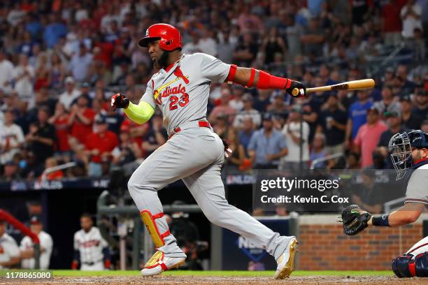 Marcell Ozuna of the St. Louis Cardinals hits a two-RBI double against the Atlanta Braves during the ninth inning in game one of the National League...