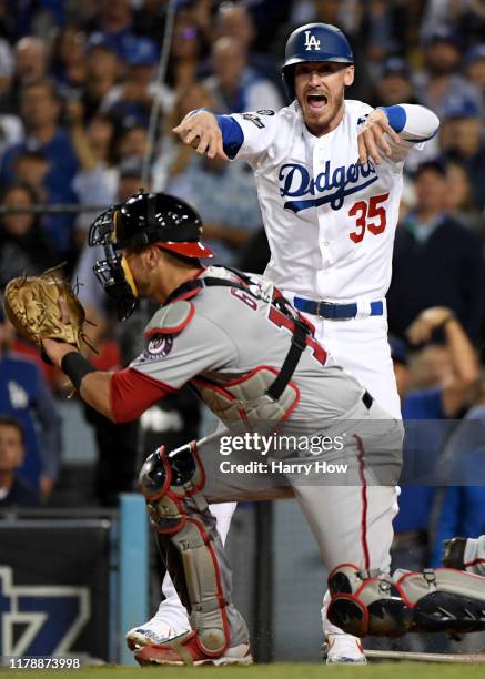 Cody Bellinger of the Los Angeles Dodgers motions to Chris Taylor at third base after he scored on an RBI single hits a by Max Muncy in the fifth...