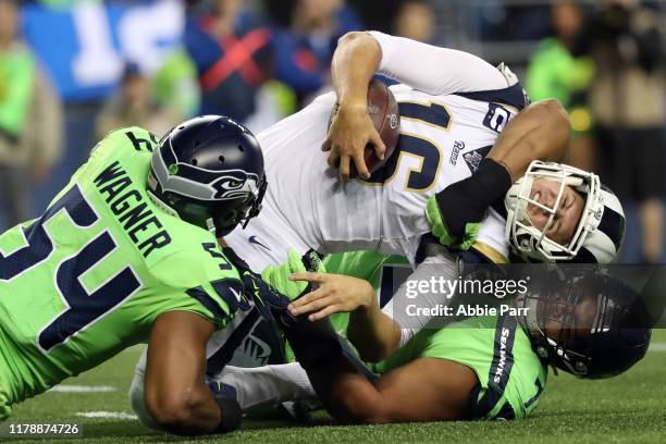 Jared Goff of the Los Angeles Rams is stopped for an unsuccessful two point conversion attempt by Bobby Wagner and Al Woods of the Seattle Seahawks...