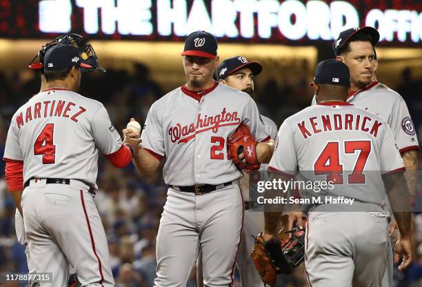 Manager Dave Martinez of the Washington Nationals relieves starting pitcher Tanner Rainey during the seventh inning of game one of the National...