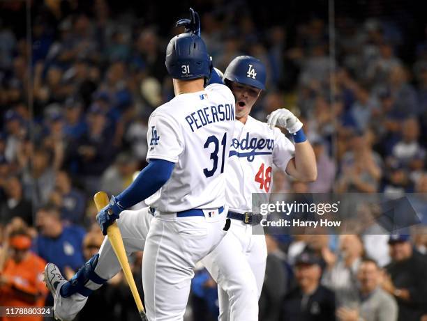 Gavin Lux of the Los Angeles Dodgers celebrates his a solo home run with teammate Joc Pederson in the eighth inning of game one of the National...