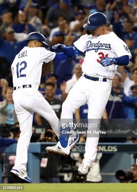Joc Pederson of the Los Angeles Dodgers celebrates with third base coach Dino Ebel after his solo home run in the eighth inning of game one of the...
