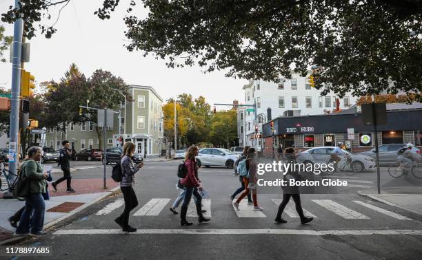 People cross the street while they take part in learning more about Inman Square's feminist history in Cambridge, MA on Oct. 21, 2019. The Cambridge...