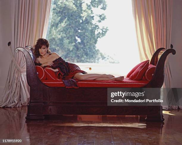 French-born Italian actress Edwige Fenech on a sofa. 1989