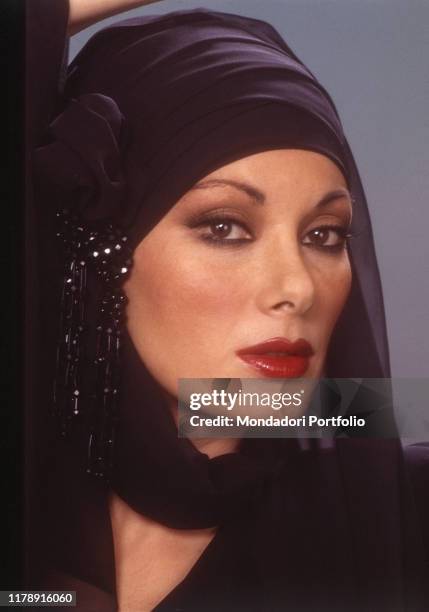 French-born Italian actress Edwige Fenech with a scarf as headstyle. 1985