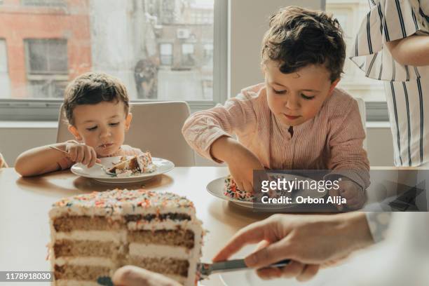 boy celebrating his third birthday - cutting cake stock pictures, royalty-free photos & images