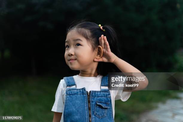 cute girl listening - listening imagens e fotografias de stock