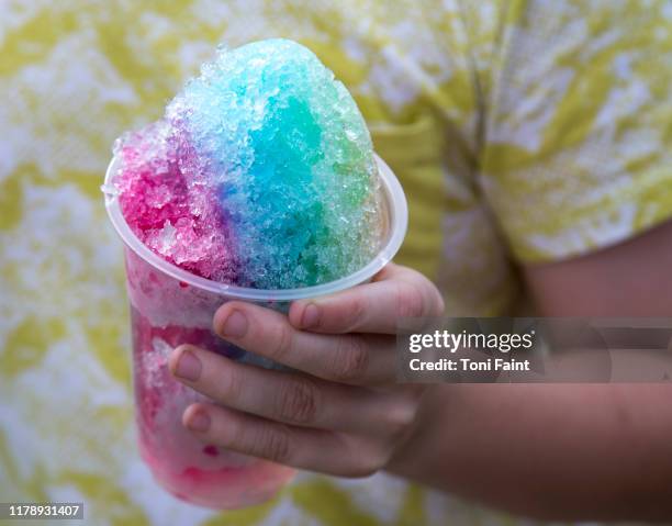 an 8 year old boy enjoying a snow cone from the markets - wassereis stock-fotos und bilder