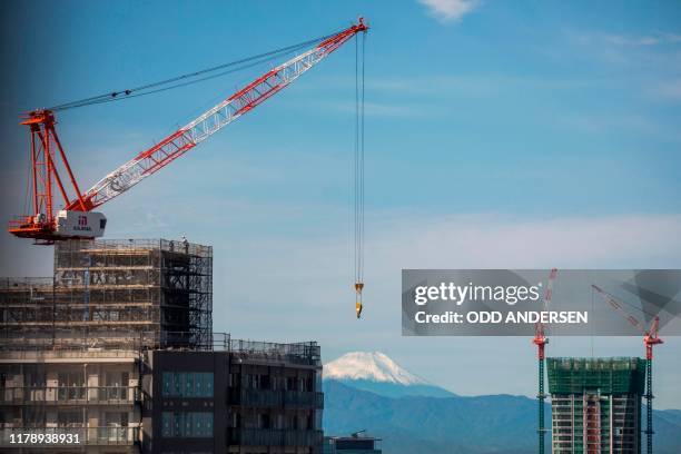 In this photo taken on October 26 Mount Fuji is seen from Tokyo behind construction sites of new high-rise buildings in the Japanese capital. - As...