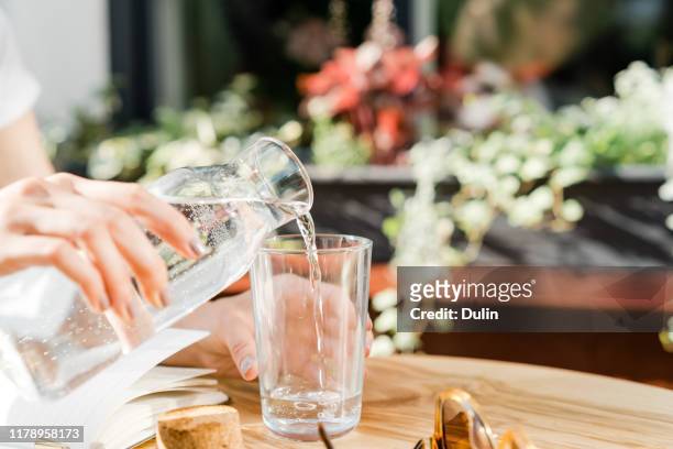 woman pouring a glass of water - karaffin bildbanksfoton och bilder