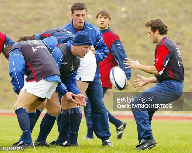 Le pilier de l'équipe de France de rugby Christian Califano effectue une passe au demi de mêlée Fabien Galthié , le 11 février 2003 au Centre...