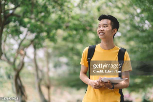 キャンパスに戻る途中、公共の公園を歩いているアジアの中国の大学の男子学生 - chinese student ストックフォトと画像