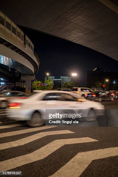 in the middle of the night, a car passes the road below the overpass, leaving a vague shadow. - speed motion lines to the middle stock pictures, royalty-free photos & images