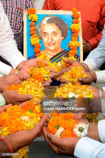 Members of All India Anti Terrorist Front shower flowers petals as they pay tribute to the late former Indian prime minister Indira Gandhi on the eve...