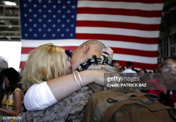 An unidentified woman kisses her fiance, a US marine with 1/3 Marines Bravo Company, upon his return to Hawaii on June 13 following a seven- month...