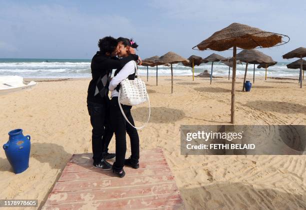 Young Tunisian couple kiss on the empty beach of Hammamet as thousands of Tunisian tour operators and residents of tourist town of Hammamet on April...