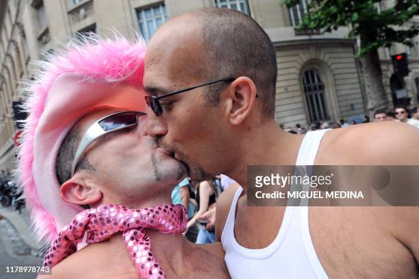 People kiss as they take part in the annual gay and lesbian pride parade on June 27 in Paris. Thousands of French gays, lesbians and transsexuals...