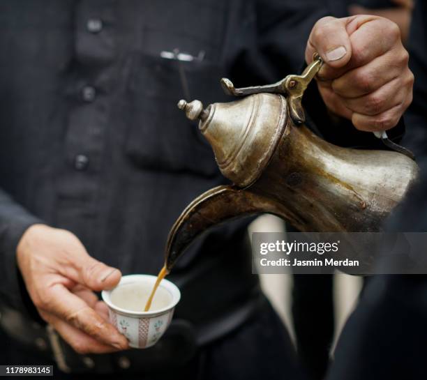 man pouring coffee in cup on street - indian market stock-fotos und bilder