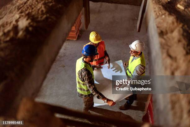 bauteam diskutiert vor ort - wiederbelebung stock-fotos und bilder