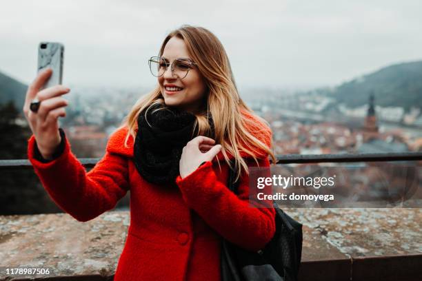 frau mit smartphone und fotografieren im heidelberger schloss - heidelberg stock-fotos und bilder