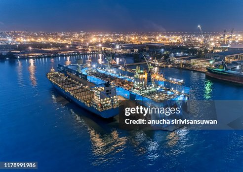 aerial view shipyard have crane machine and container ship in sea .