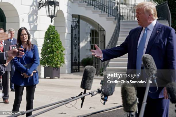 White House Press Secretary Stephanie Grisham looks on as U.S.President Donald Trump talks to journalists on the South Lawn of the White House before...