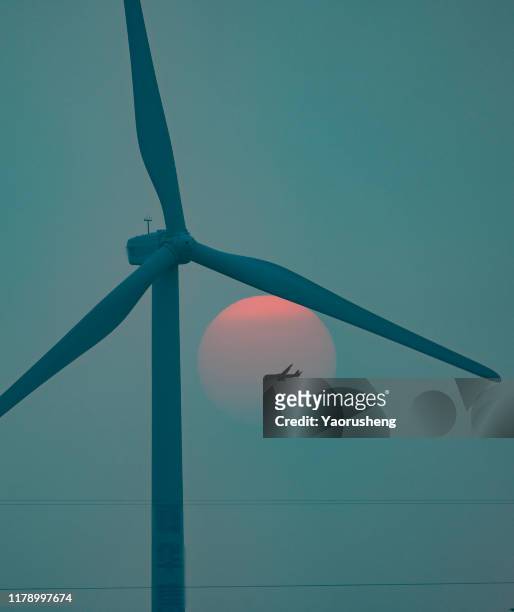 aeroplan flying pass the windmill in the beautiful sunset - farm pollution stock pictures, royalty-free photos & images