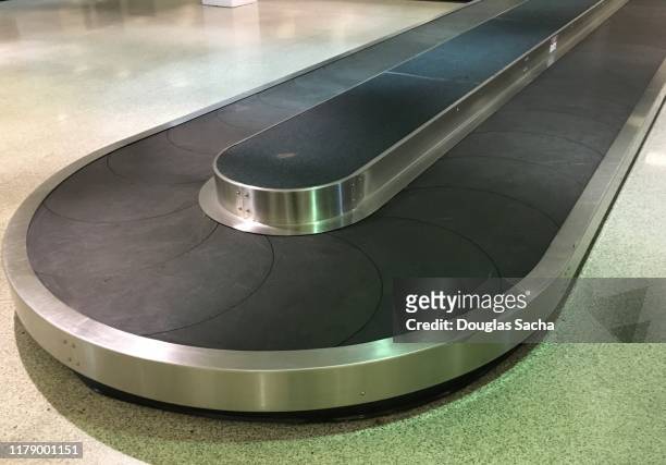 luggage conveyor at the airport terminal - zona de equipajes fotografías e imágenes de stock