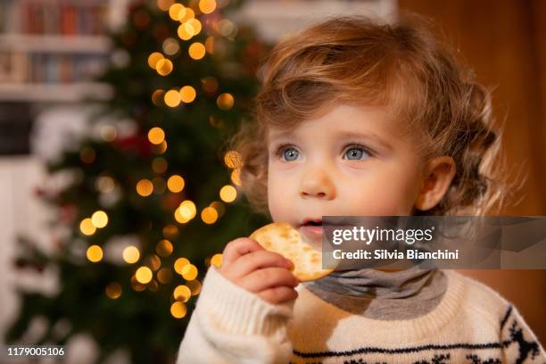 porträt eines kleinen mädchens mit einem plätzchen zu weihnachten - baby christmas stock-fotos und bilder