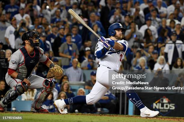 Max Muncy of the Los Angeles Dodgers watches his two run singles against the Washington Nationals in the seventh inning of game one of the National...