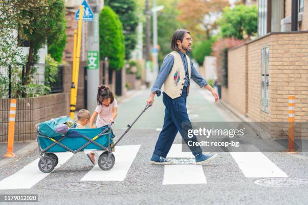 father carrying his children on wagon cart after picnic - side view carrying stock pictures, royalty-free photos & images