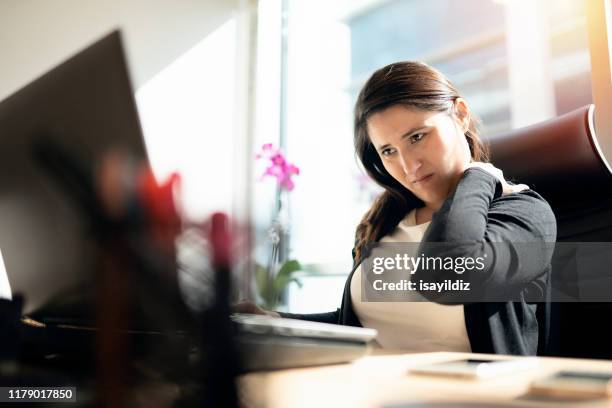 imprenditrice stanca che tiene la nuca - postura ufficio foto e immagini stock