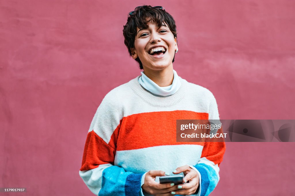 Portrait of a young hipster girl holding phone