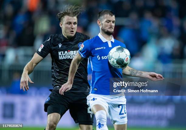 Marcel Heller of Darmstadt is challenged by Marco Thiede of Karlsruhe during the Second Bundesliga match between SV Darmstadt 98 and Karlsruher SC at...