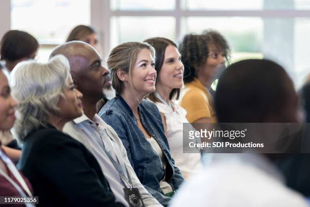 diverse audience members sitting in row enjoy speaker - attending college stock pictures, royalty-free photos & images