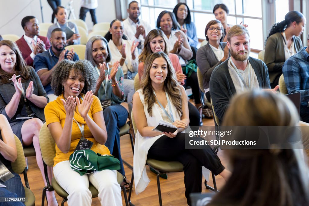 Unrecognizable speaker receives applause at expo
