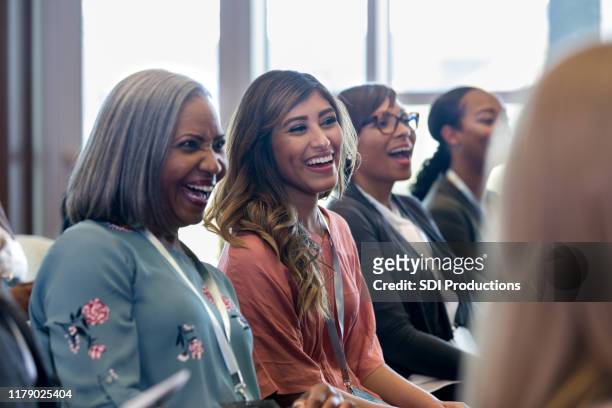 diverse women enjoy laugh during expo session - only women stock pictures, royalty-free photos & images