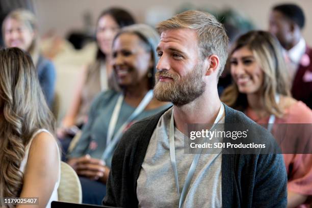 mid adult male hipster listens to unseen conference speaker - attending conference stock pictures, royalty-free photos & images