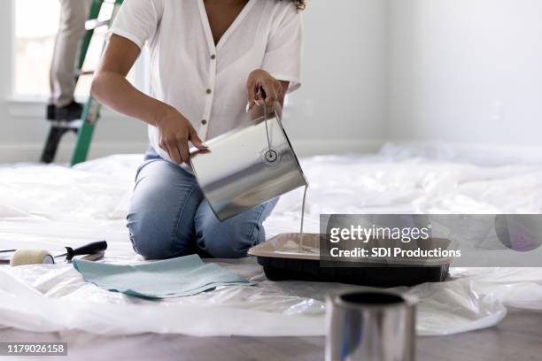 mujer irreconocible vertiendo pintura - paint tray fotografías e imágenes de stock