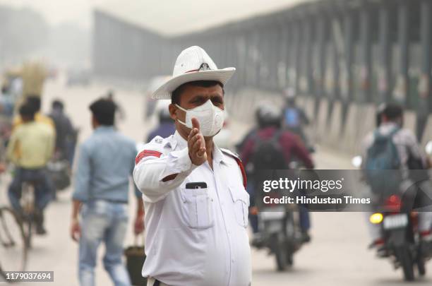 Traffic police personnel is seen wearing a face mask on duty due to rise in pollution, on October 30, 2019 in Gurugram, India. Smog, that appears as...