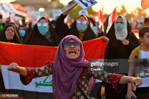 An Iraqi women chant slogans and wave their country's national flag during during anti-government protests in the central Iraqi holy city of Najaf on...