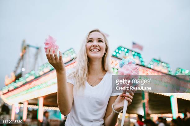 teenage woman enjoying state fair food - cotton candy stock pictures, royalty-free photos & images