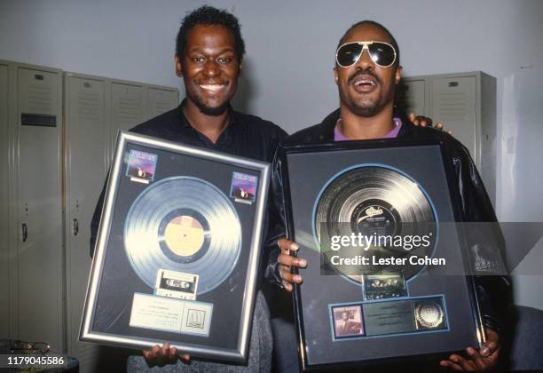 Luther Vandross and Stevie Wonder pose with a platinum record sales plaque for the album 'The Night I Fell In Love' circa 1985. (Photo by Lester...