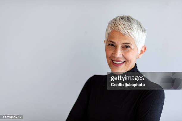 zuversichtliche seniorin - portrait grey background stock-fotos und bilder