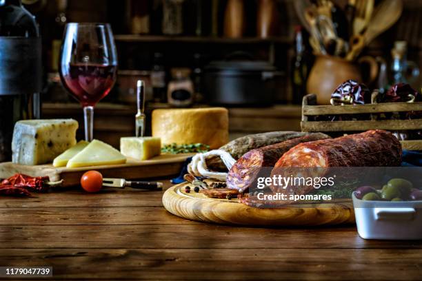 tapas de queso, jamón curado, vino de salami y chorizo sobre una mesa rústica de madera - charcutería-italiana fotografías e imágenes de stock