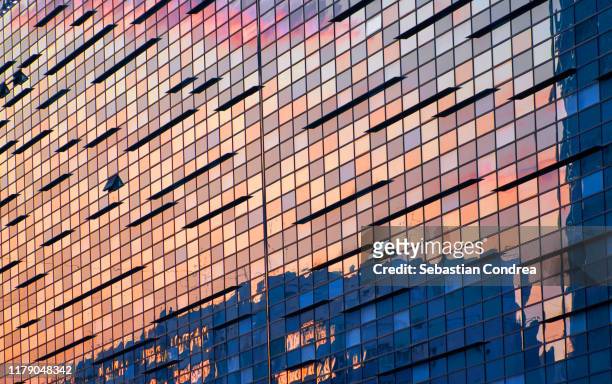 illuminated office building at sunset. bucuresti, romania. - wall building feature stock pictures, royalty-free photos & images