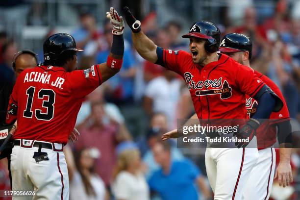 Adam Duvall of the Atlanta Braves celebrates with Ronald Acuna Jr. #13 after a two-run home run off Jack Flaherty of the St. Louis Cardinals in the...