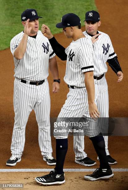 Aaron Judge of the New York Yankees high-fives his teammates prior to game one of the American League Division Series against the Minnesota Twins at...